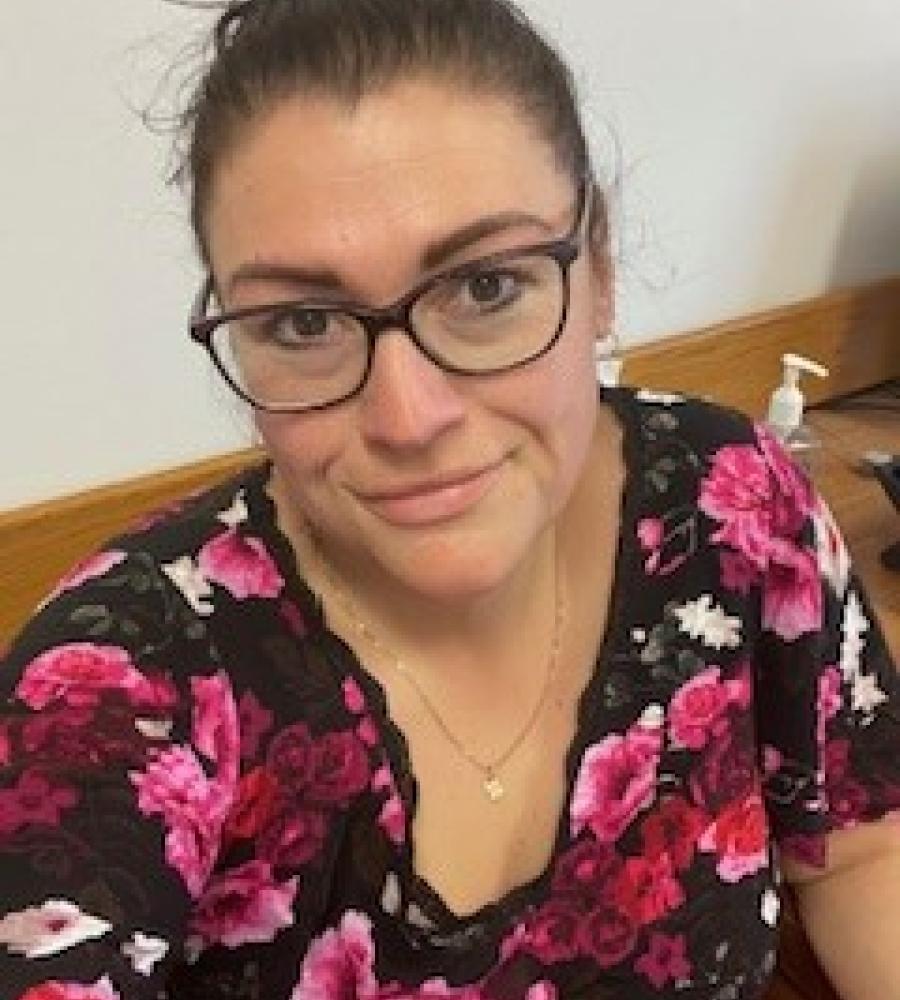 photo of Jocelyne smiling, she is wearing glasses and a floral shirt